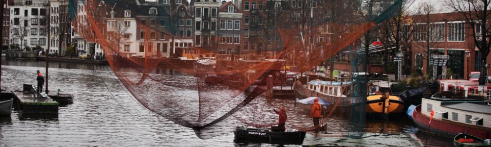 De opbouw van het kunstwerk 1.26 Amsterdam op de Amstel. We zien 2 technici vanaf een elektrische boot op het water het werk prepareren.