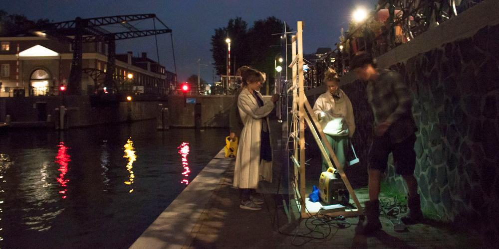 De studenten doen een lichttest, met een prototype van het werk.