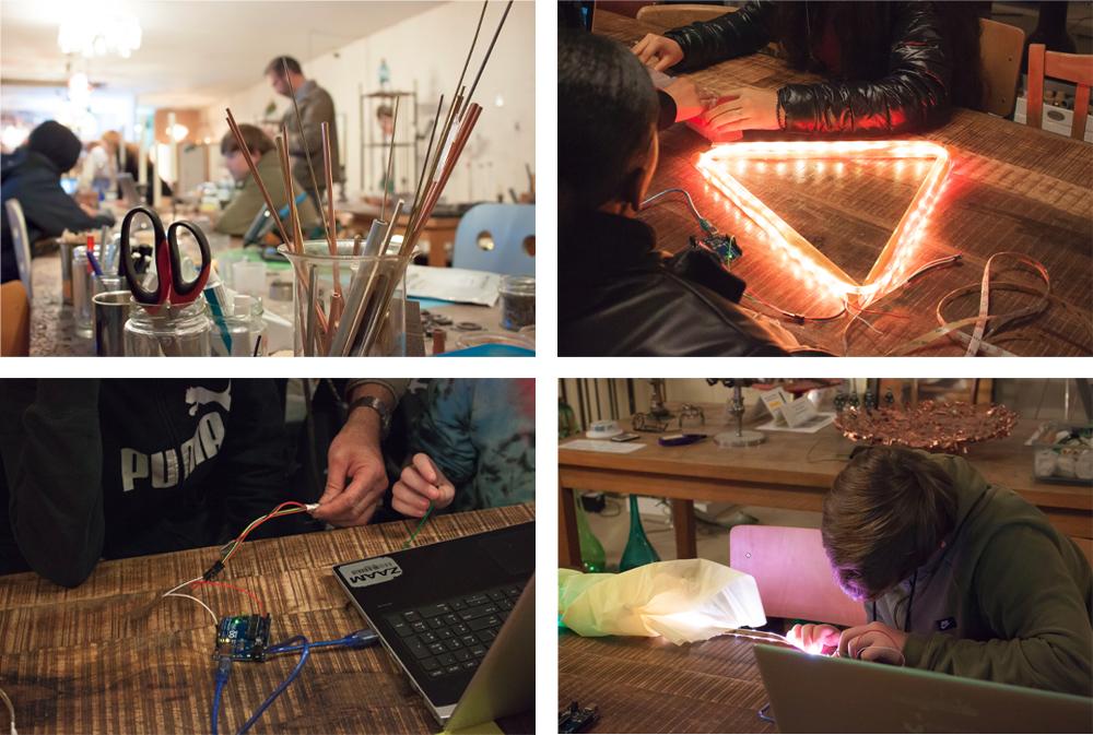 Leerlingen met een Ledstrip in de vorm van een vlaggetje, elektriciteitsdraden en druk in bespreking met elkaar.